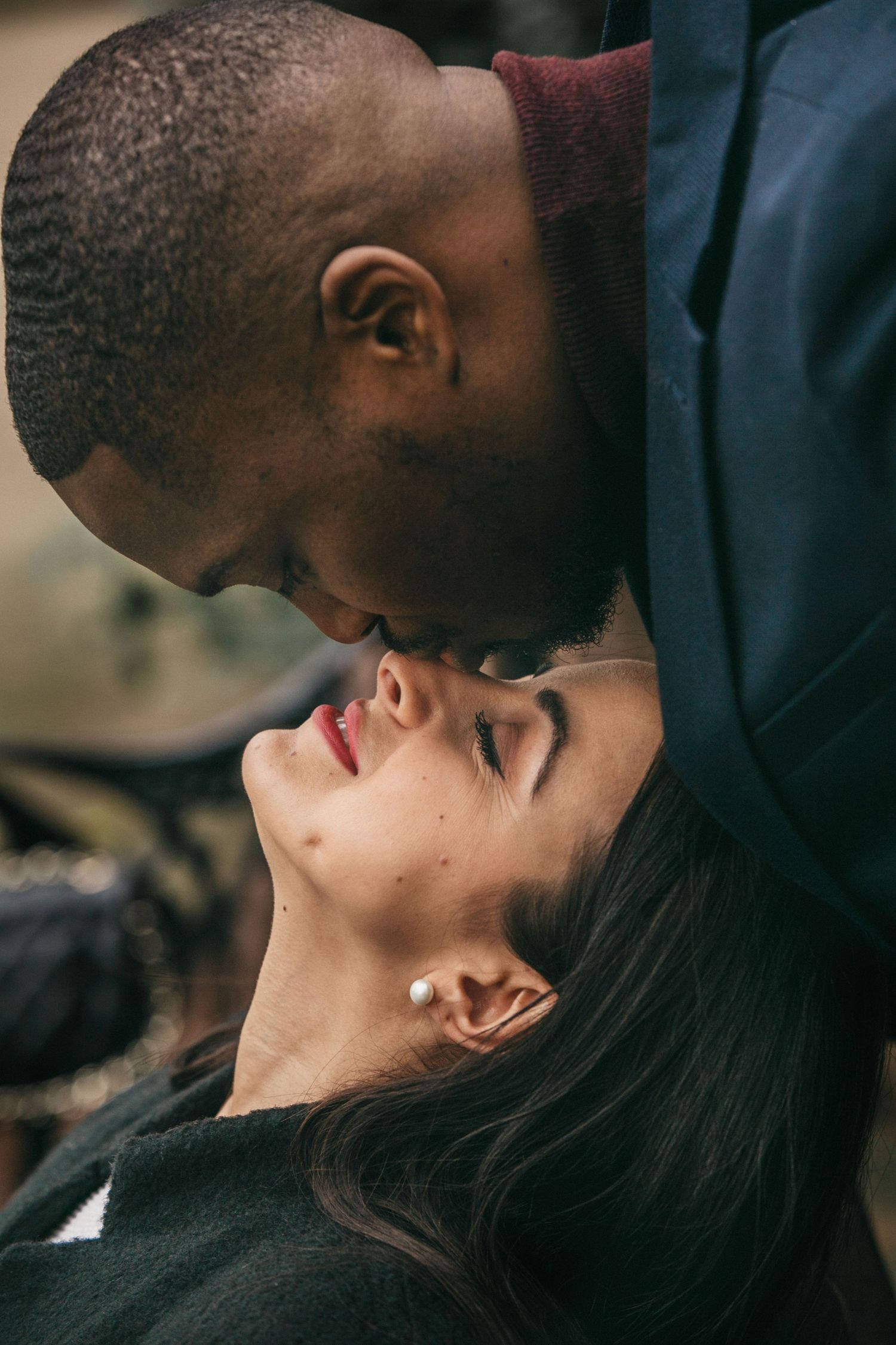 A tender and intimate moment between a couple in black clothing sharing a romantic close embrace.