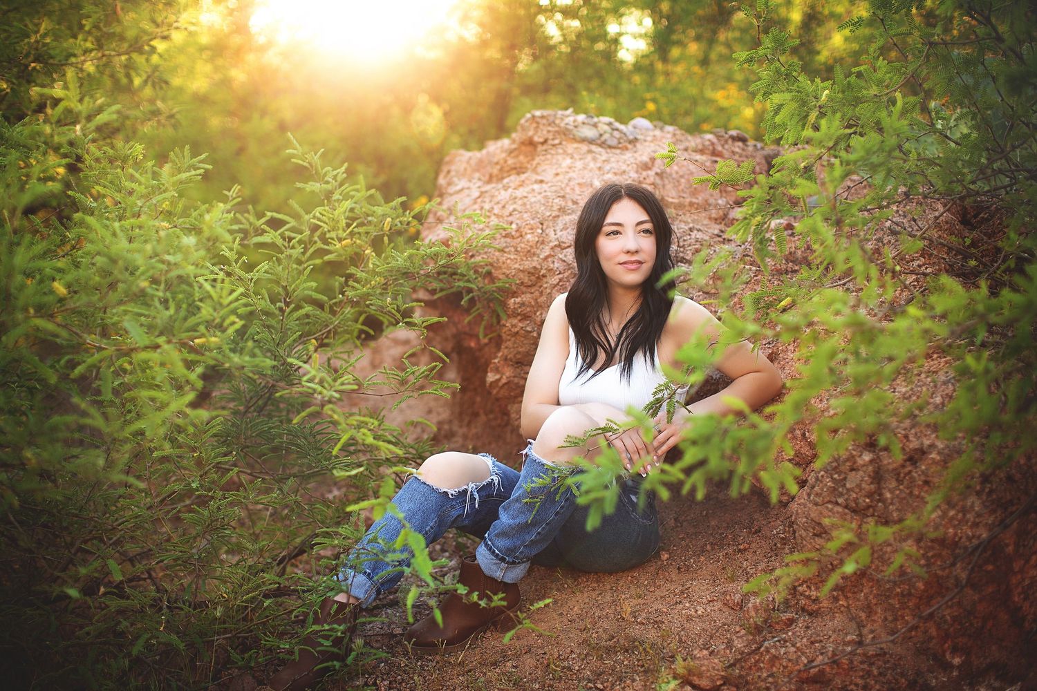 Nature portrait session among green foliage and flowers.