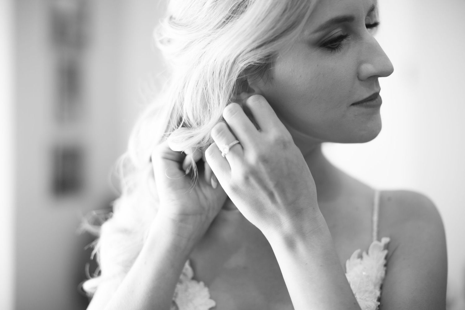 Black and white portrait showing elegant wedding day jewelry and accessories.