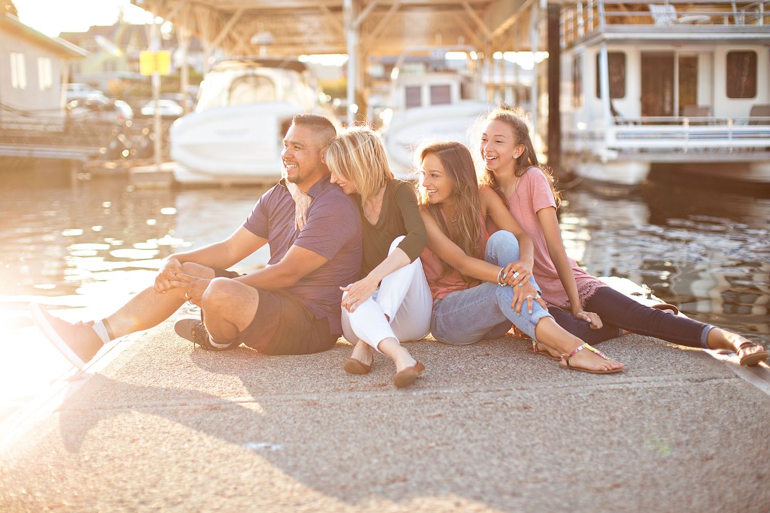 Group relaxing together on a dock by the water during sunset.