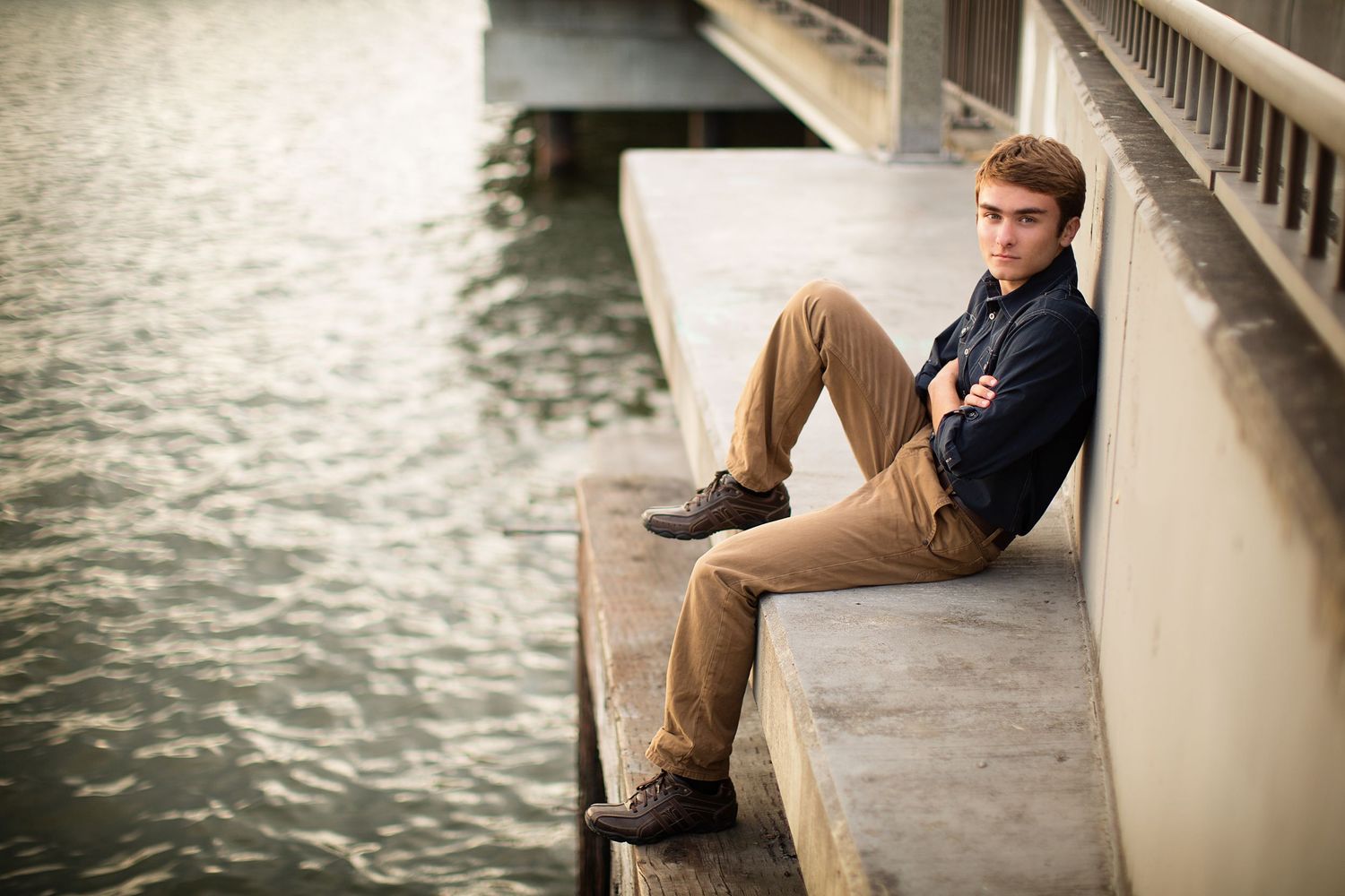 Senior portrait session along a waterfront boardwalk at sunset.