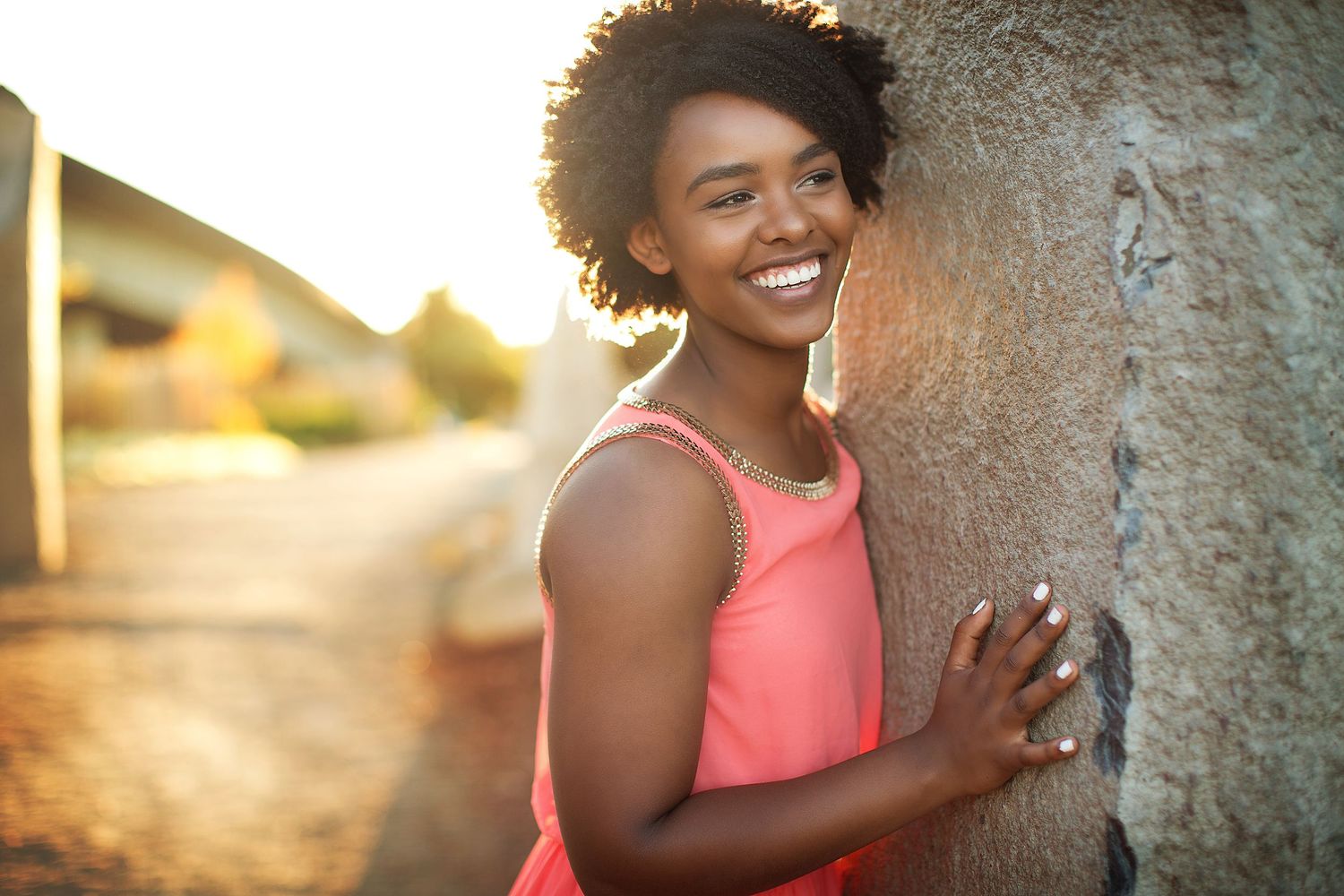 Joyful outdoor portrait session against textured stone walls in natural light.
