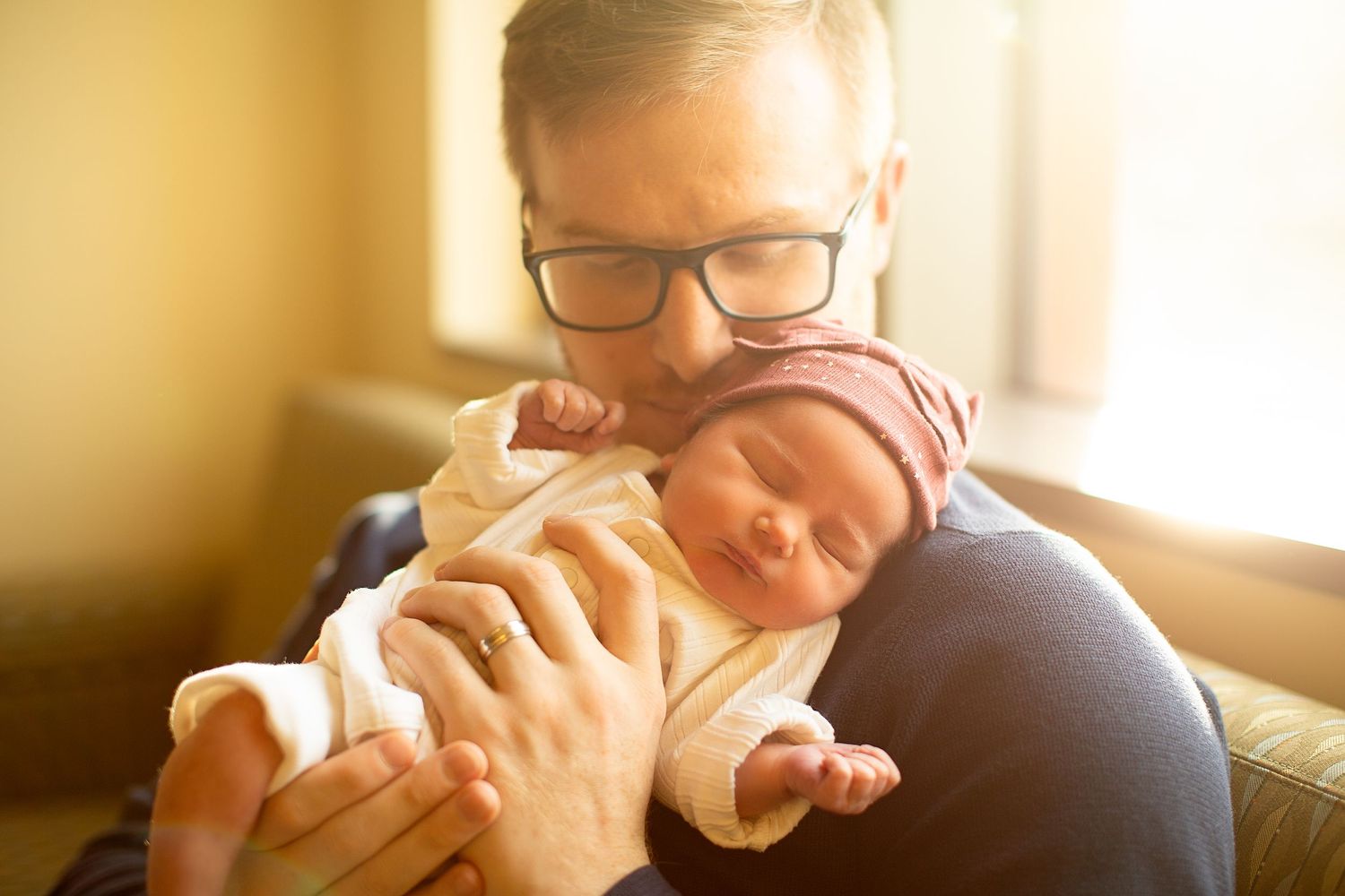 A tender moment between parent and baby in a warmly lit room.