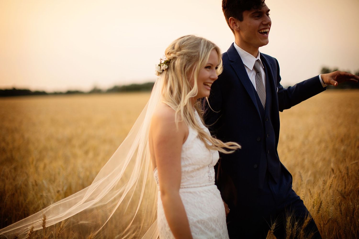 Couple shares intimate moments among tall wheat stalks during golden hour.
