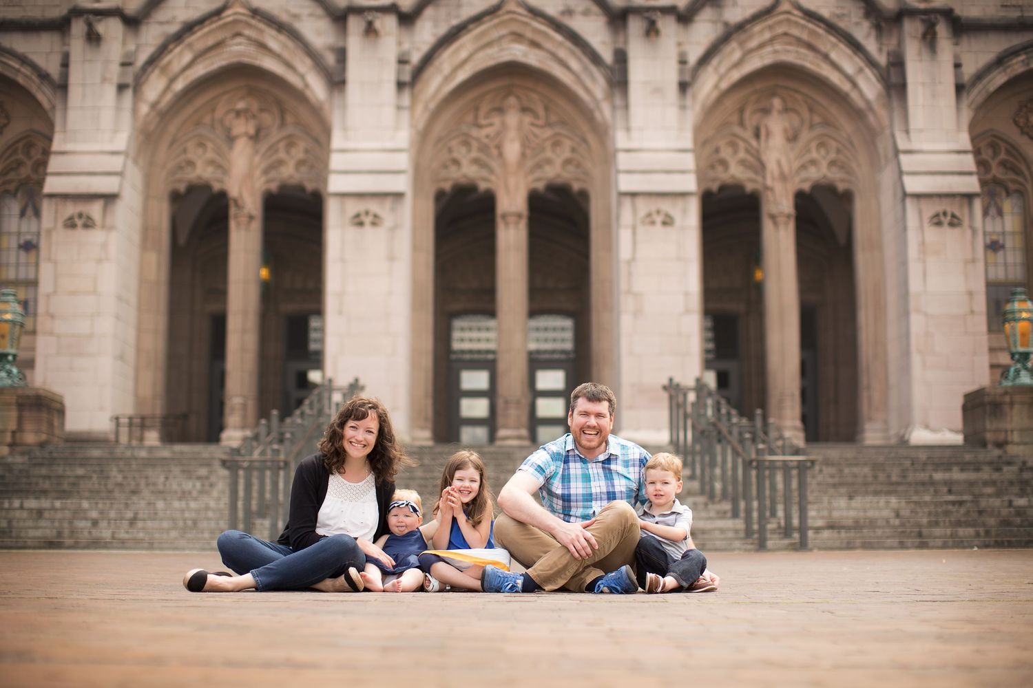 Family portrait session in front of ornate Gothic stone architecture.