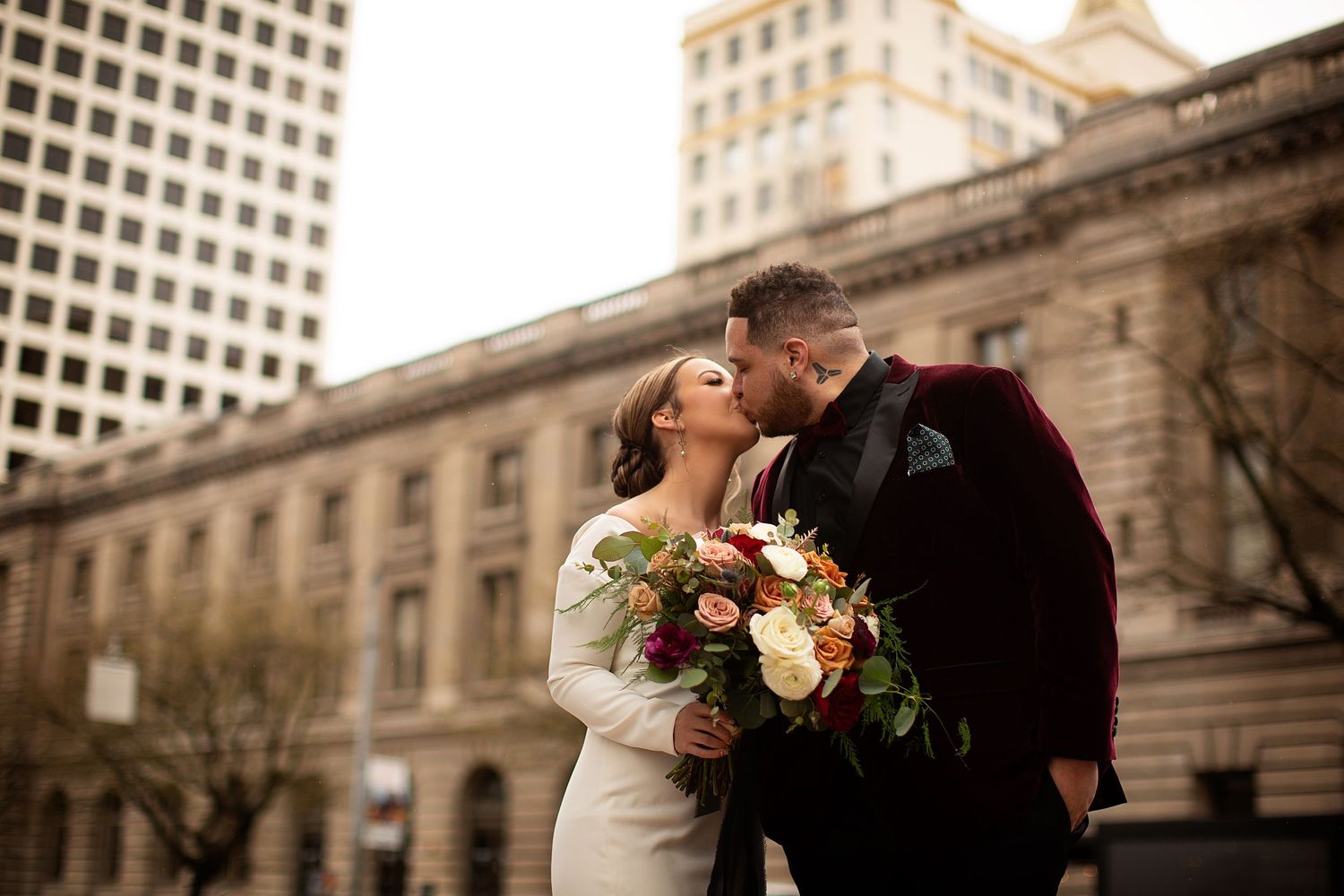 Classic urban wedding photography against historic building architecture.