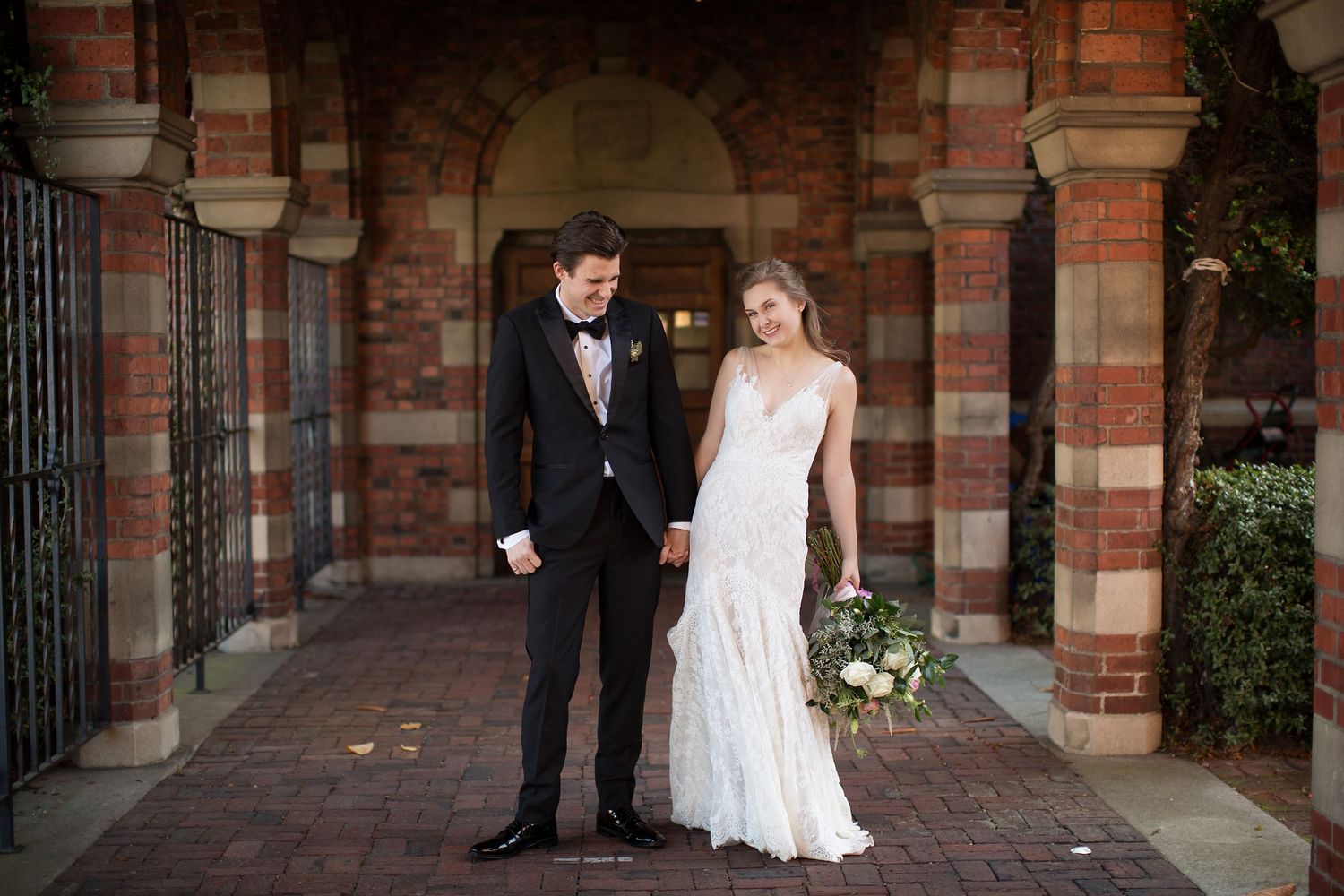 Elegant wedding portraits captured against classic brick architecture.