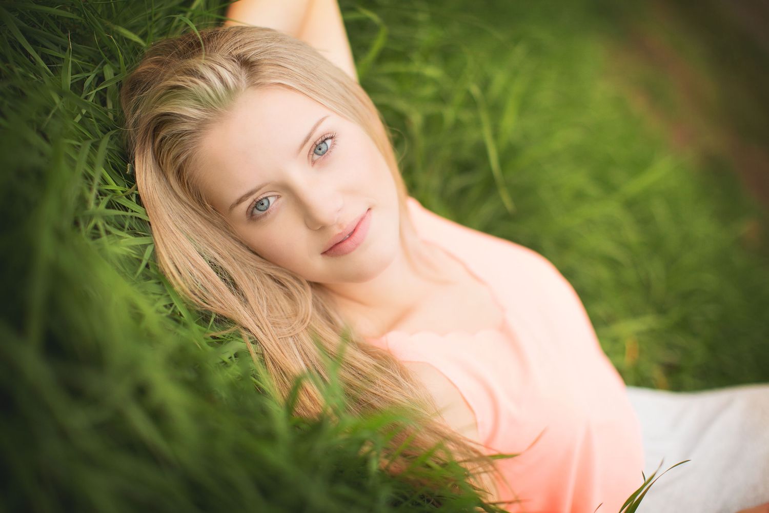 Dreamy outdoor portraits in lush green grass with soft focus effects.