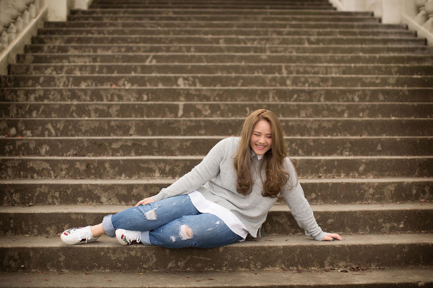 Creative portrait series on concrete steps with casual poses and natural lighting.