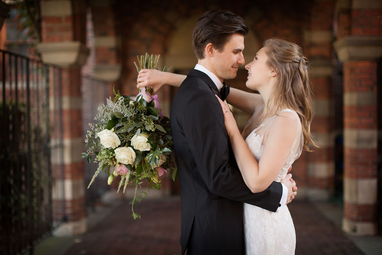 Romantic wedding couple shares intimate moments in an architectural setting.