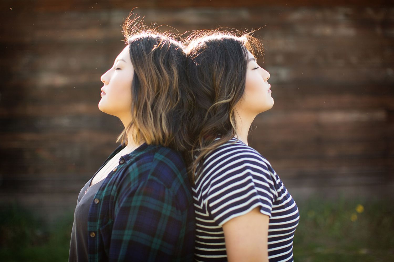 Artistic side profile portraits against rustic wooden wall background.