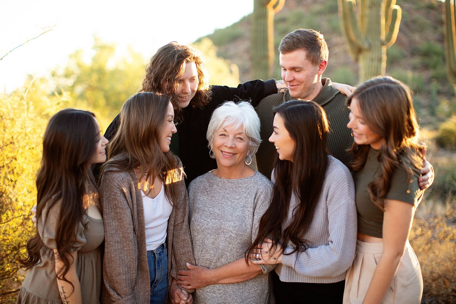 Group of friends laughing together outdoors during golden hour.