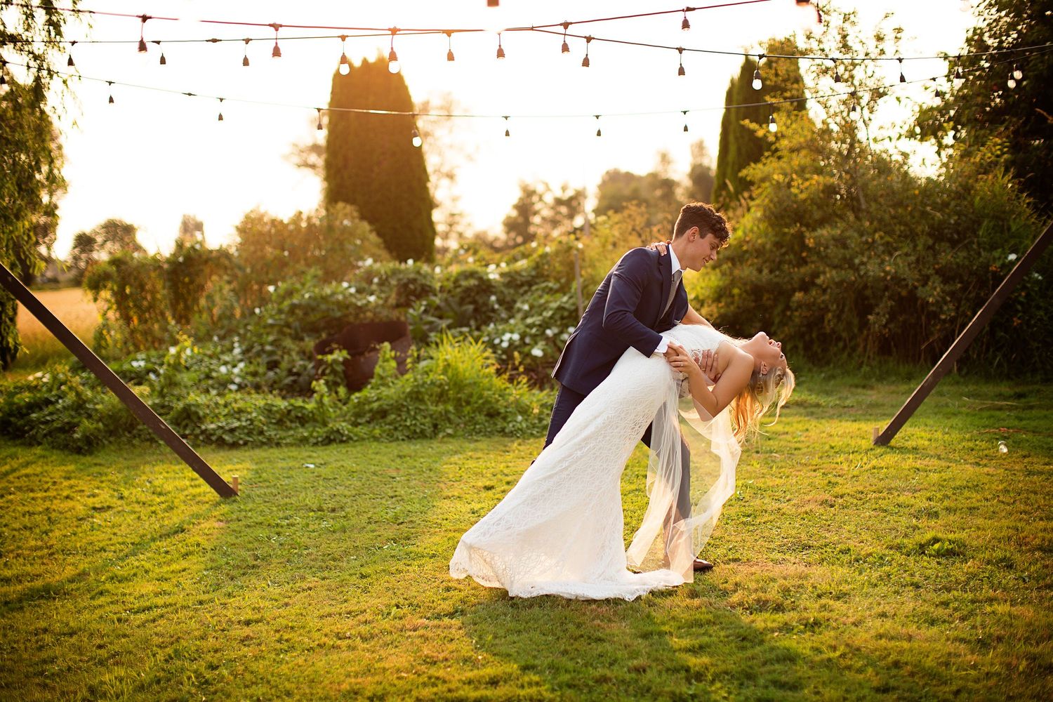 Wedding celebration under string lights in an outdoor garden setting.