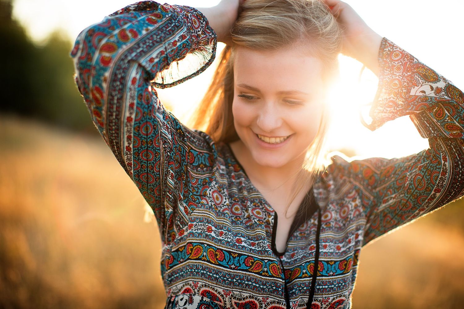 Person wearing patterned top photographed in golden sunlight.