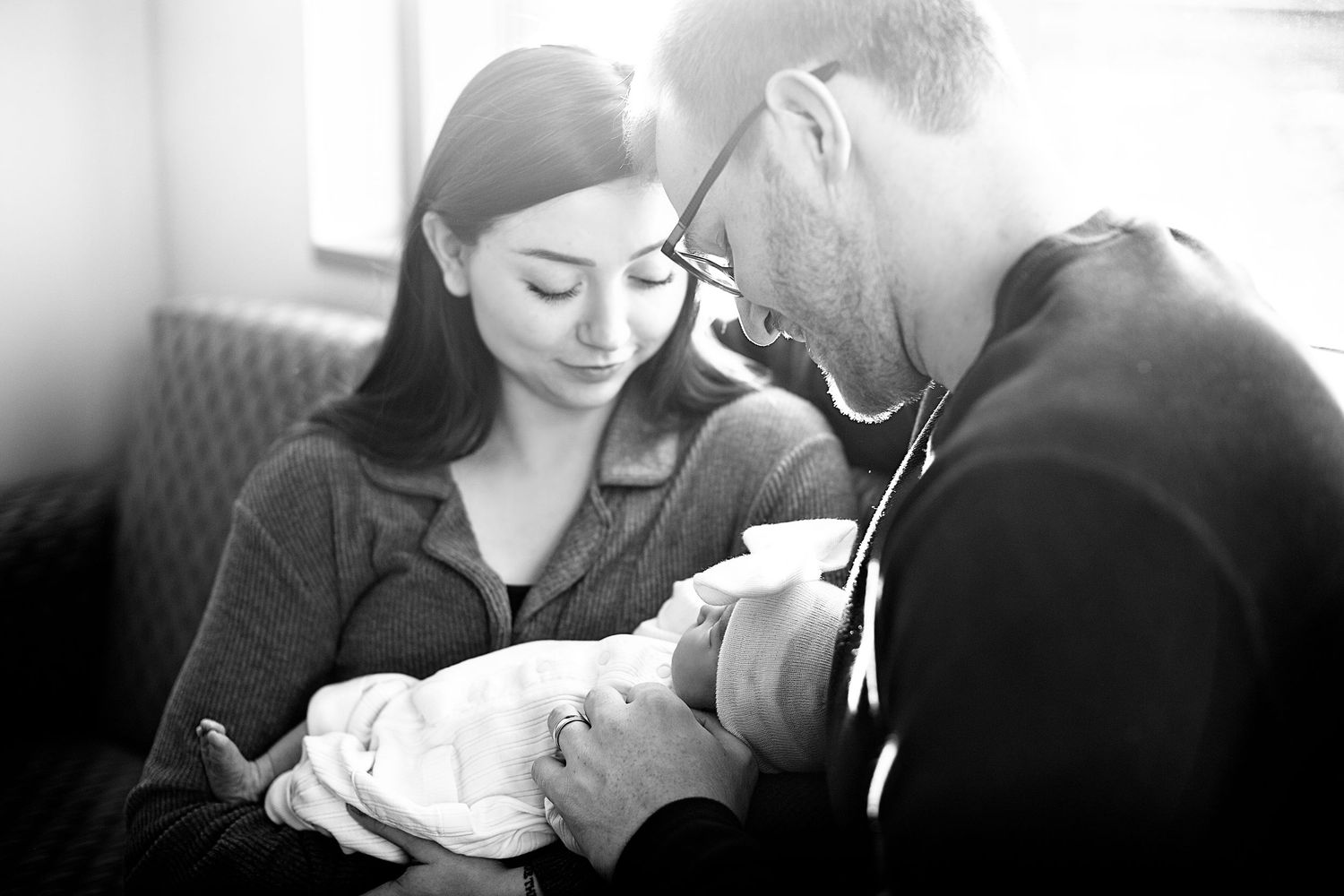 An intimate black and white portrait of a family sharing a quiet moment together.