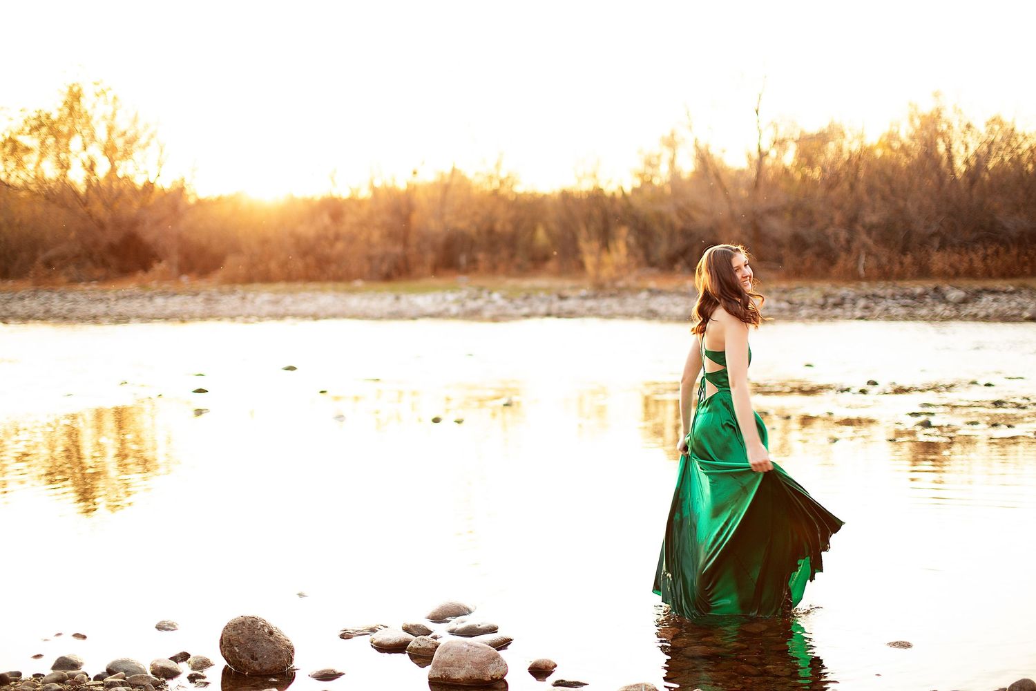Dramatic waterfront portraits in emerald green dress at sunset.