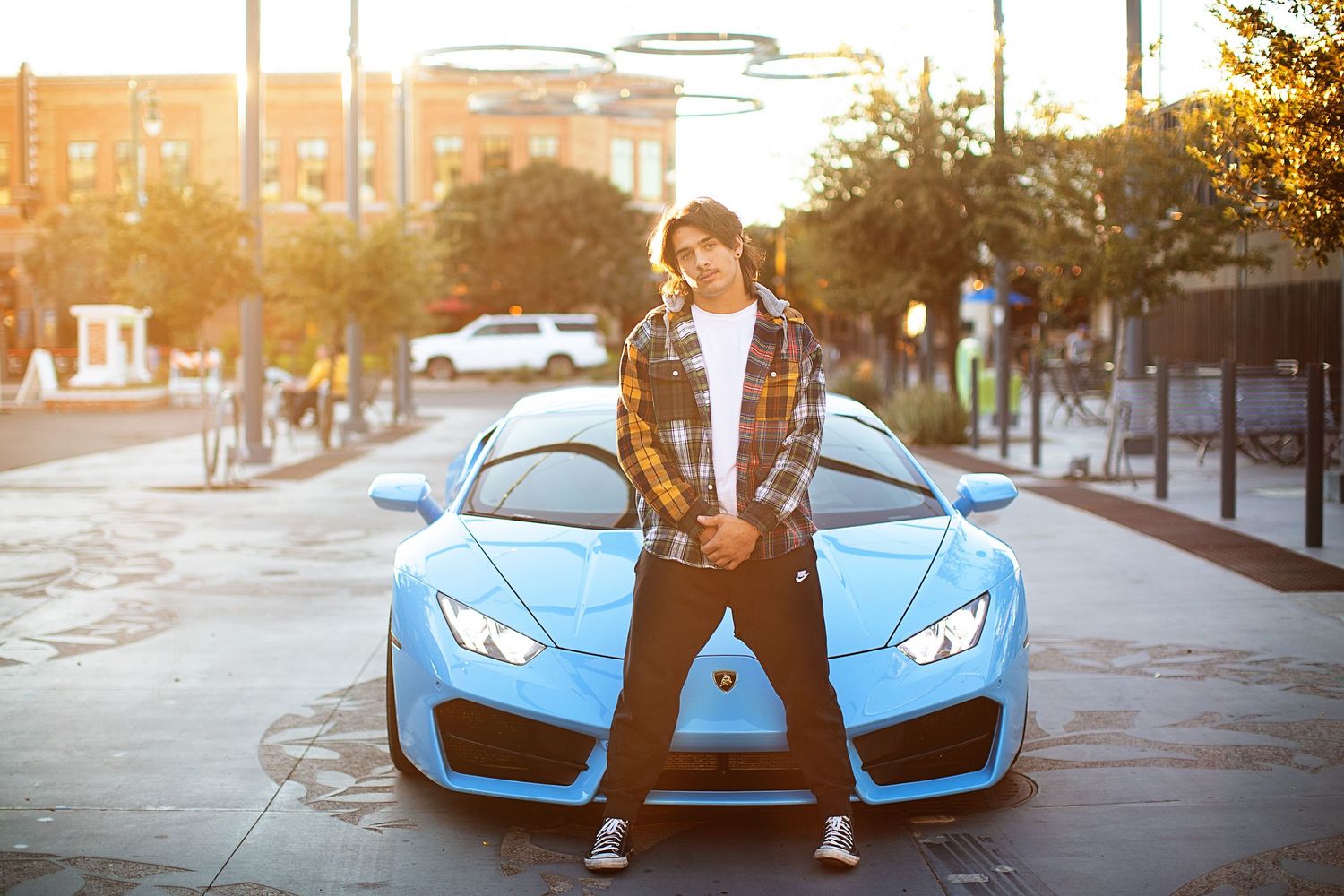 Lifestyle photos with bright blue sports car on city street at golden hour.