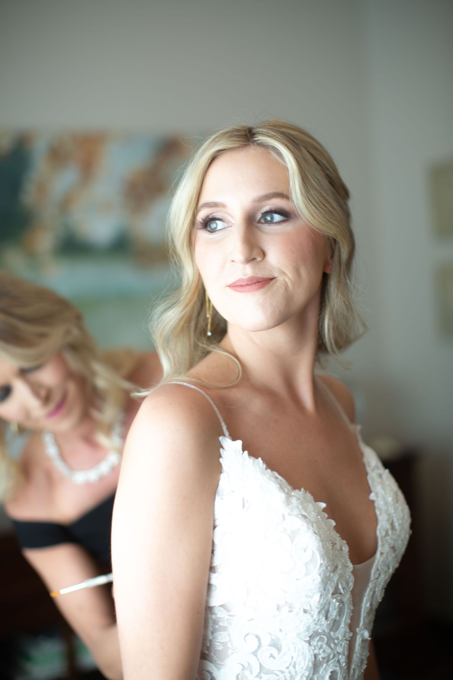 Close-up details of a lace wedding gown with delicate straps and intricate embroidery.
