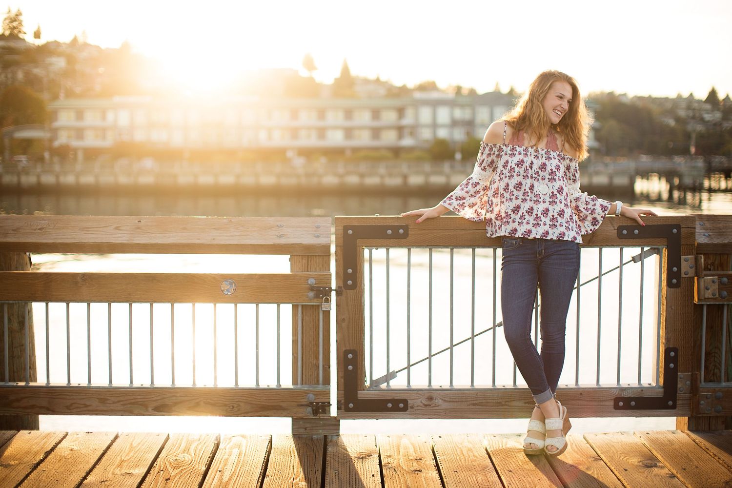 Golden hour portraits on a wooden dock with sunlit water backdrop.