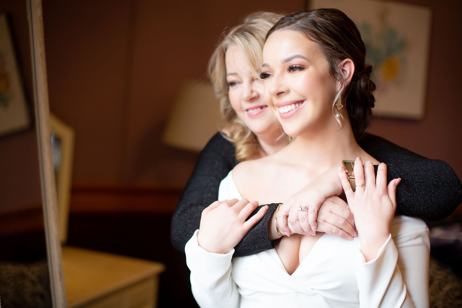 Two people share a joyful embrace while wearing formal attire.