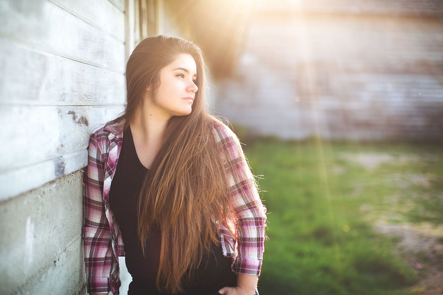 Moody portraits featuring plaid shirt and long hair with soft window lighting.