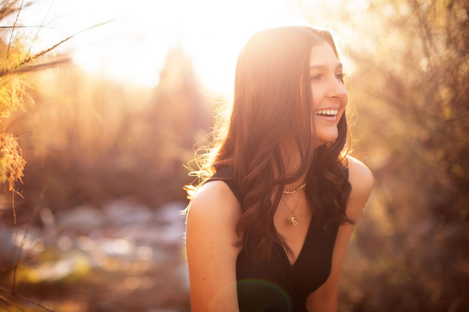 Natural light portrait with warm sunset glow in background.