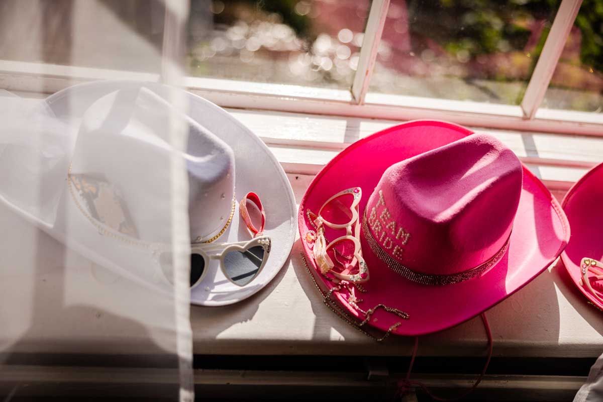 Valkoinen ja pinkki stetsoni ja sydämen muotoiset aurinkolasit ikkunalaudalla.