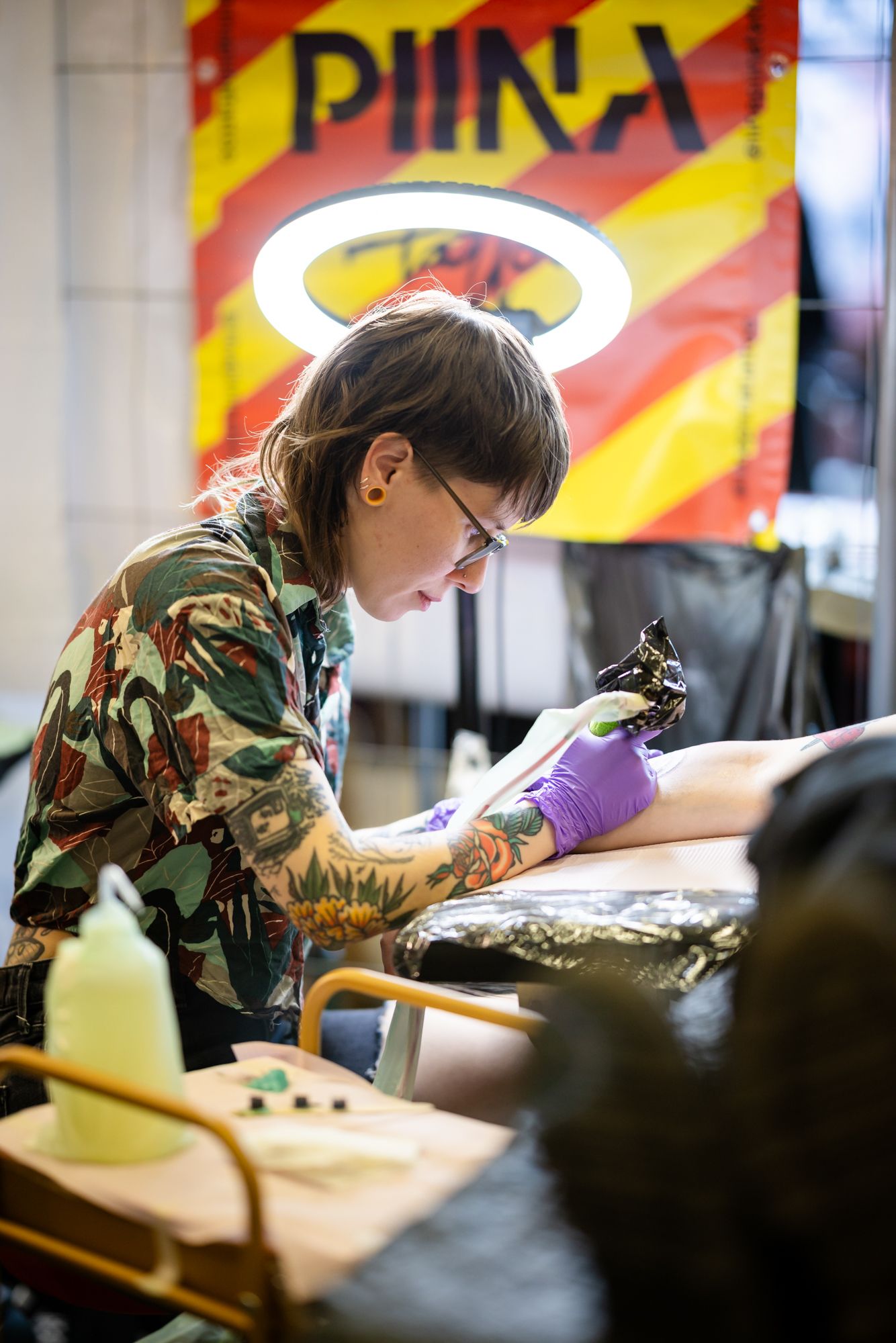 Tatuointiartisti tekemässä tatuointia asiakkaalle