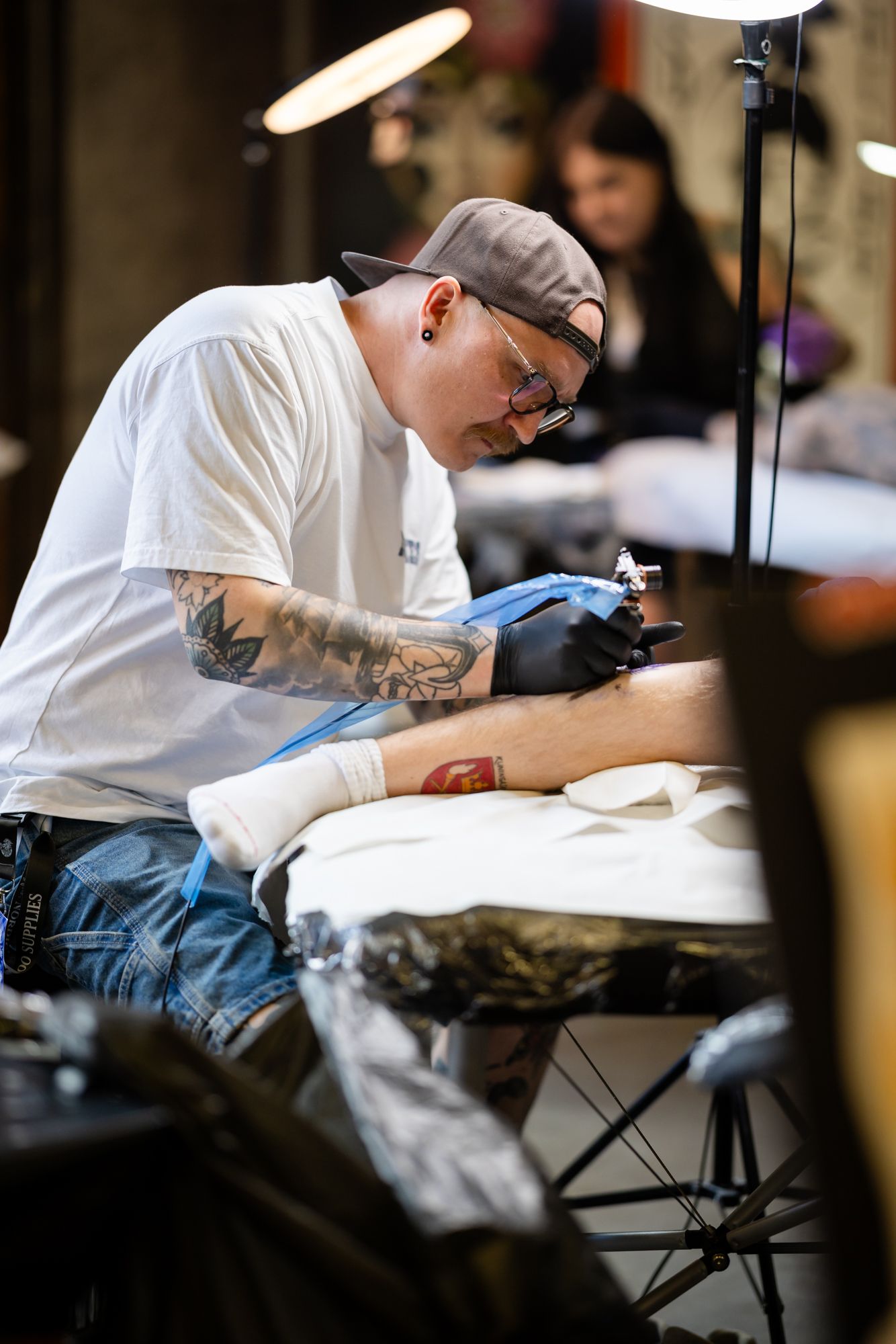 Tatuointiartisti tekemässä tatuointia asiakkaalle