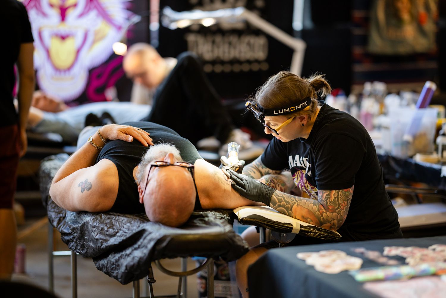 Tatuointiartisti tekemässä tatuointia asiakkaalle