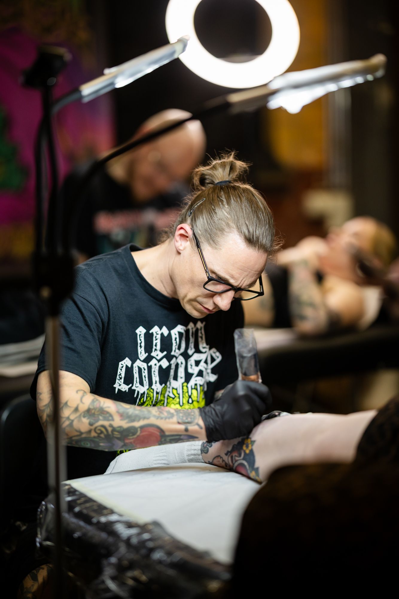 Tatuointiartisti Jussi Kokkarinen tekemässä tatuointia asiakkaalle