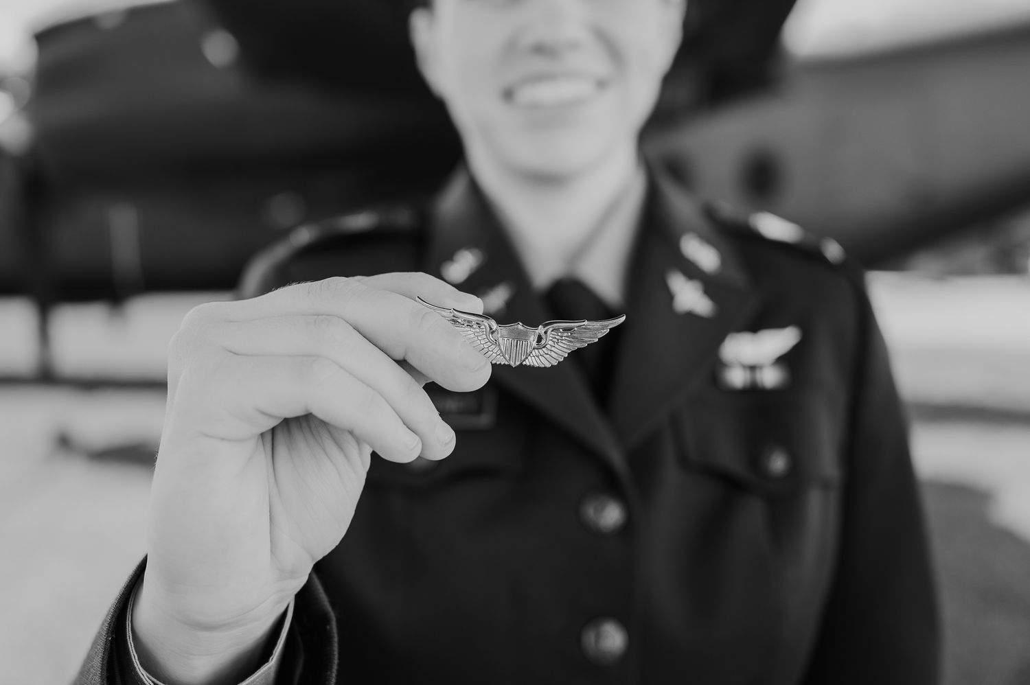 Military personnel in uniform stand together outdoors while holding coins during an awards ceremony.