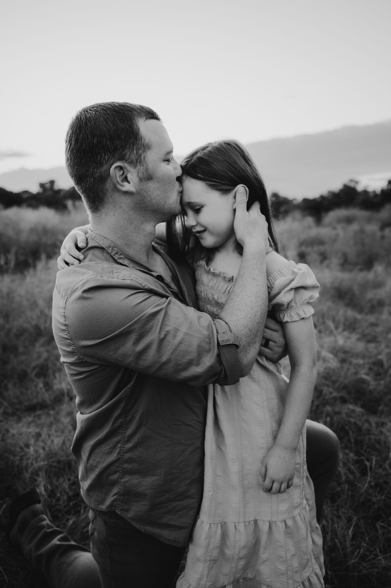 Intimate black and white photo sequence of a couple sharing sweet moments in nature at sunset.