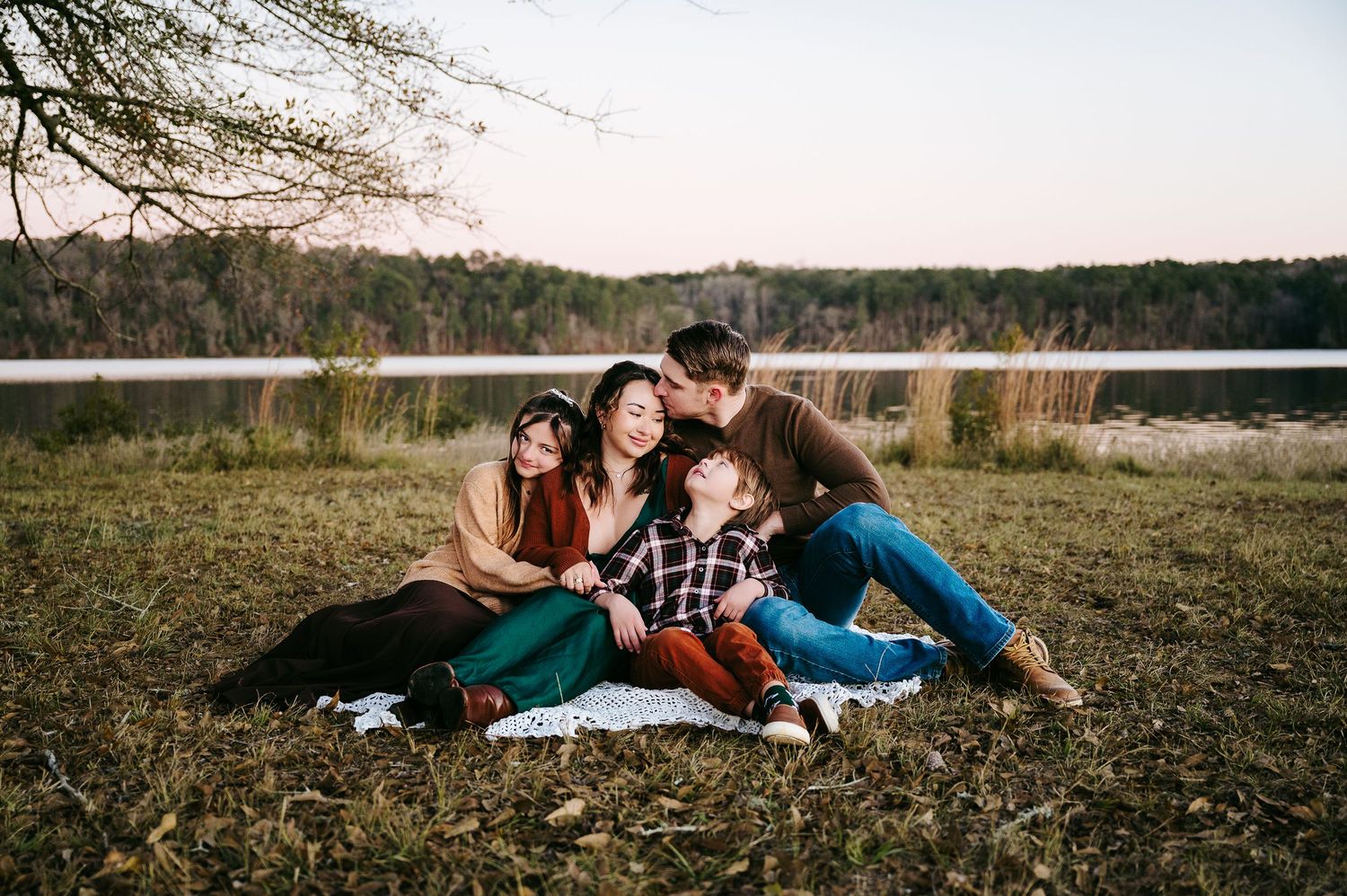 Couple laying together on autumn grass in a romantic outdoor photoshoot series.