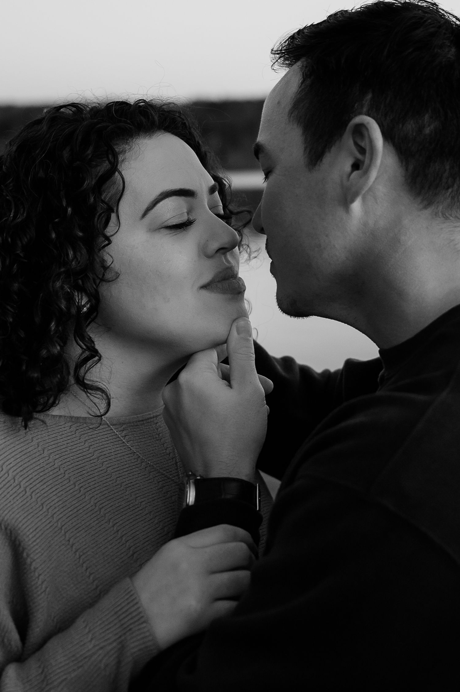 A romantic black and white photo sequence showing an intimate couple sharing tender kisses and embraces.
