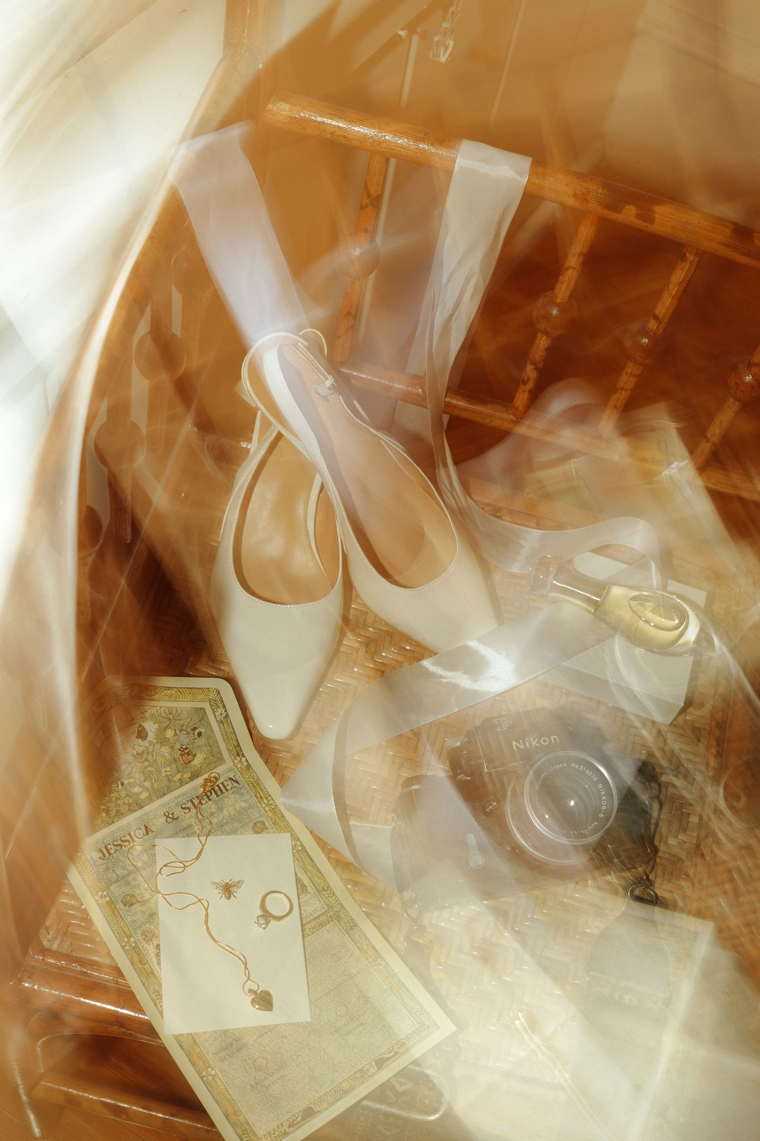A dreamy romantic still life with white ballet shoes, vintage postcards and photographs in warm sepia tones.