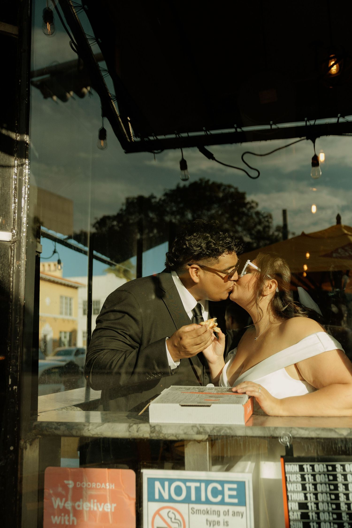 A couple shares a romantic moment at a cafe counter with vintage decor and lighting.