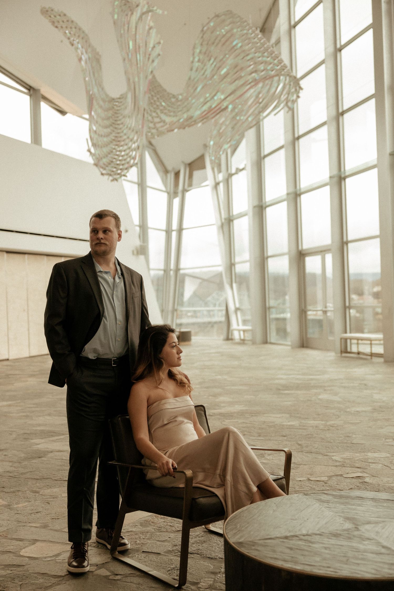 A series of minimalist photographs showing a person sitting in a chair within a stark, light-filled architectural space.