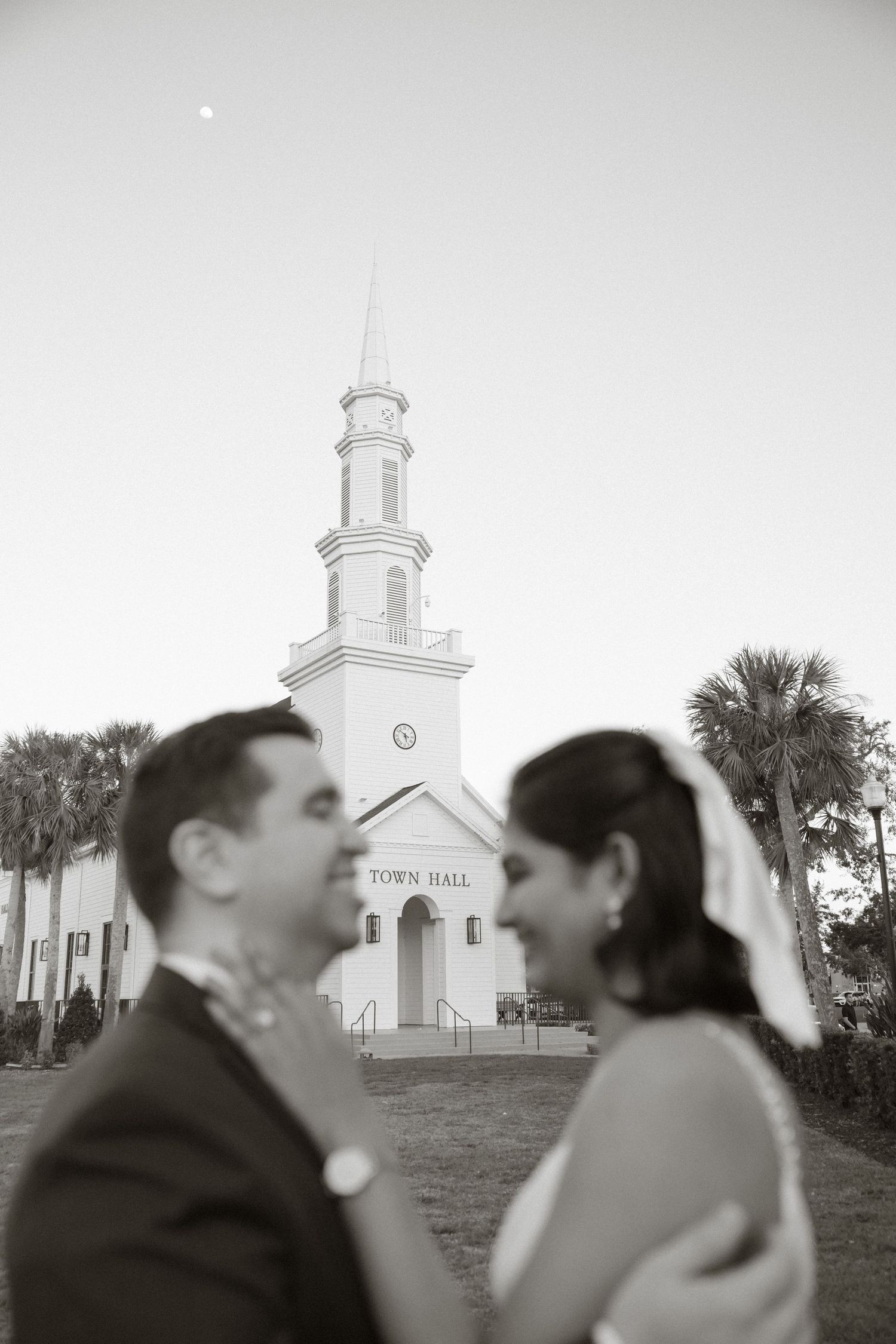 Black and white panoramic triptych showing a church in background with silhouetted figures in the foreground during an event.