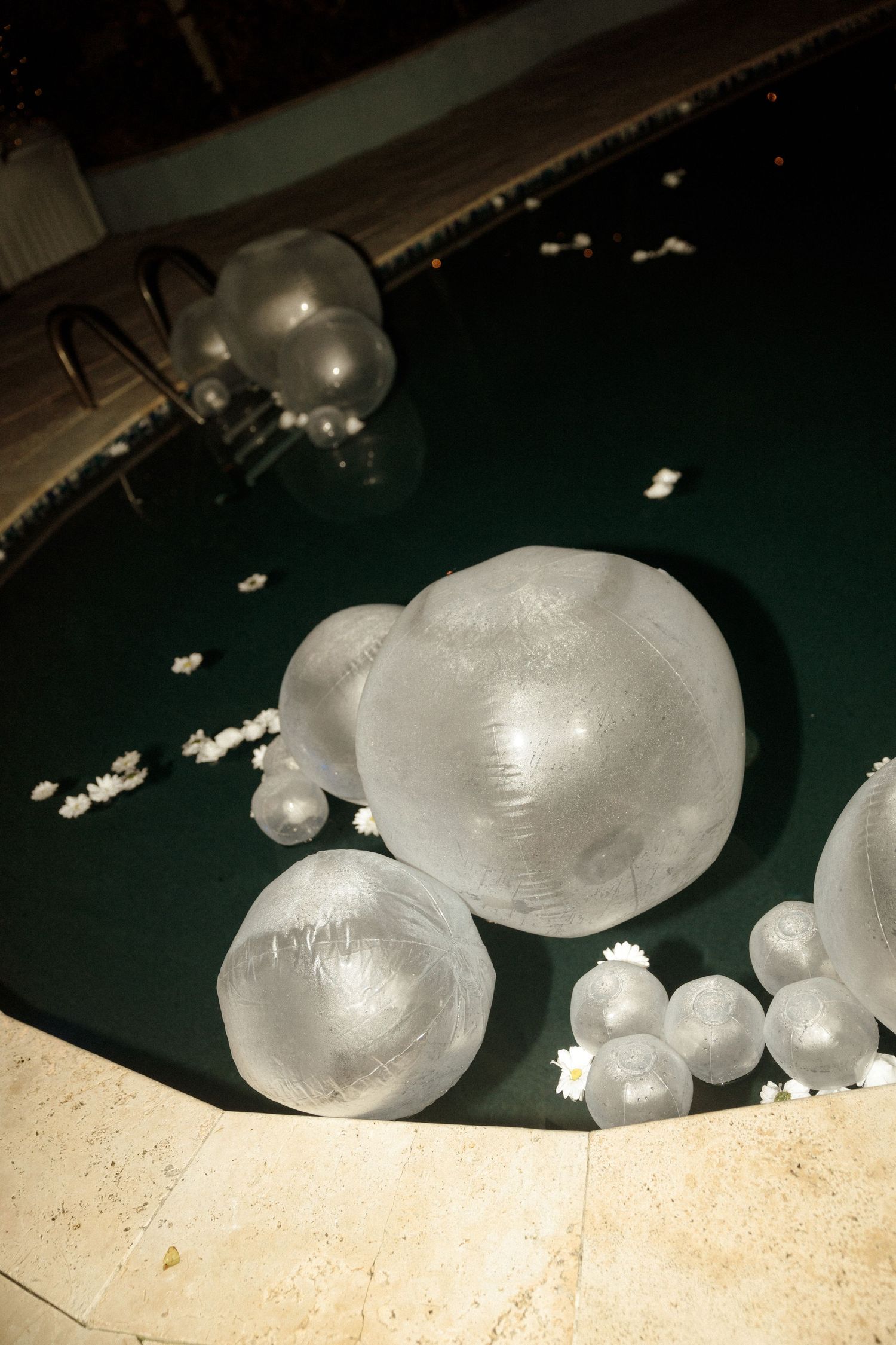Large ice spheres and hailstones on a dark green surface.