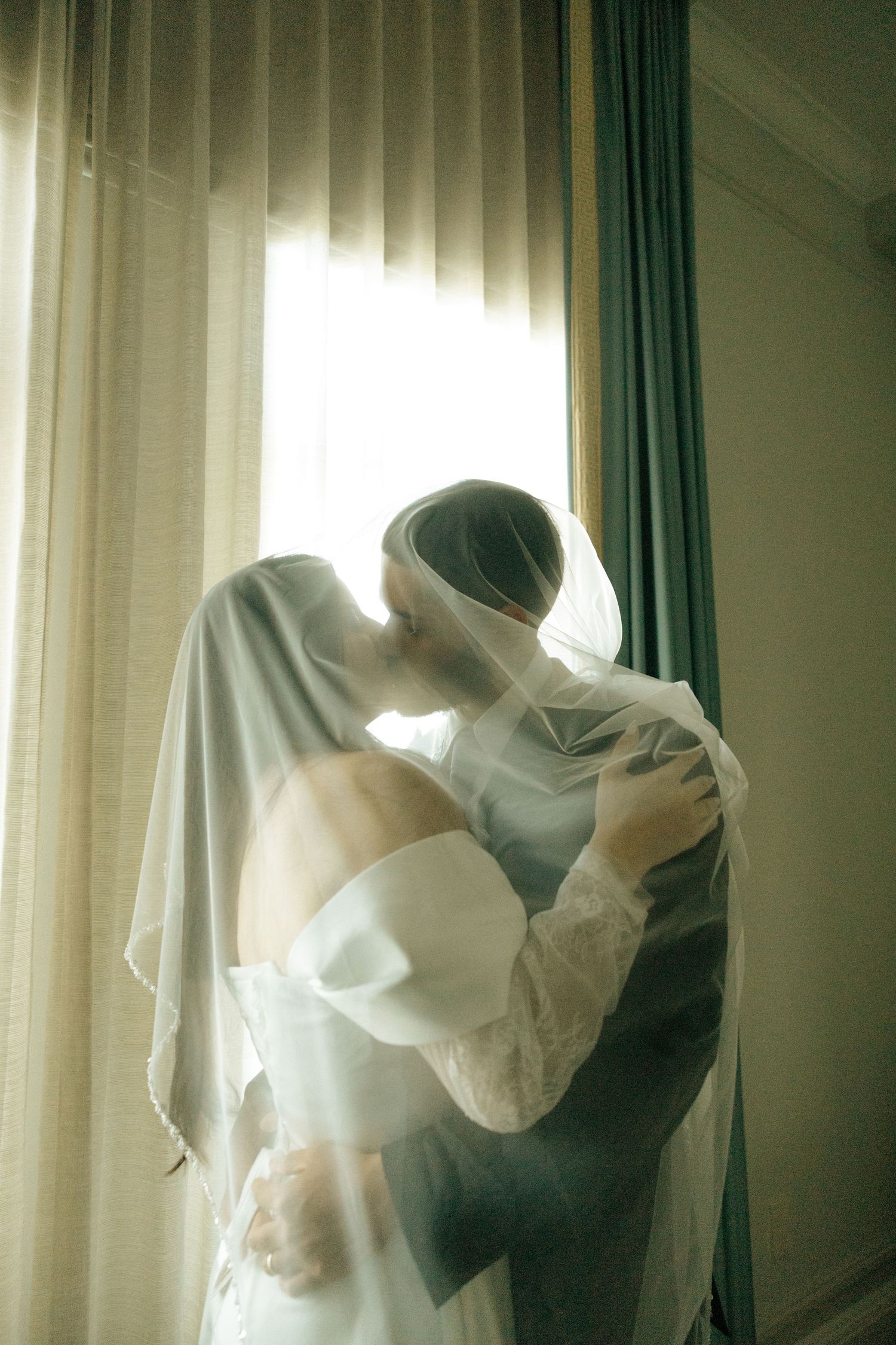 Ethereal white fabric drapes flow in soft motion against a window, creating a dreamy minimalist scene in natural light.