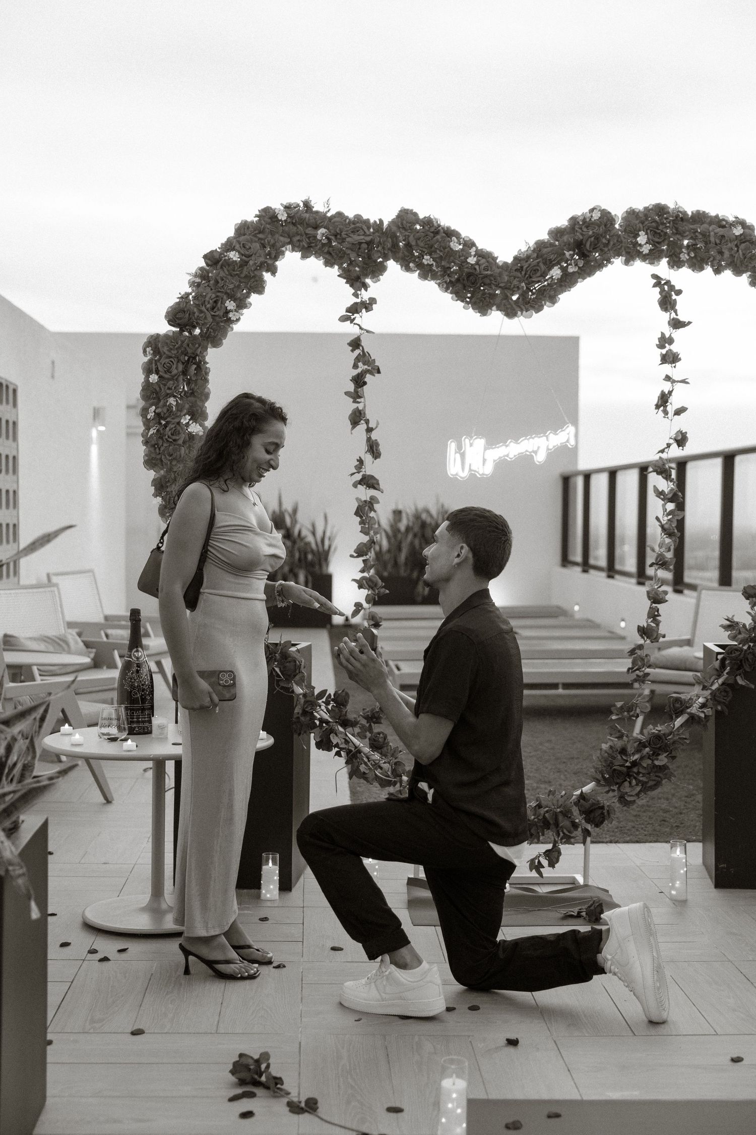 A sequence of black and white photographs shows a proposal at a scenic overlook with a view of the water.