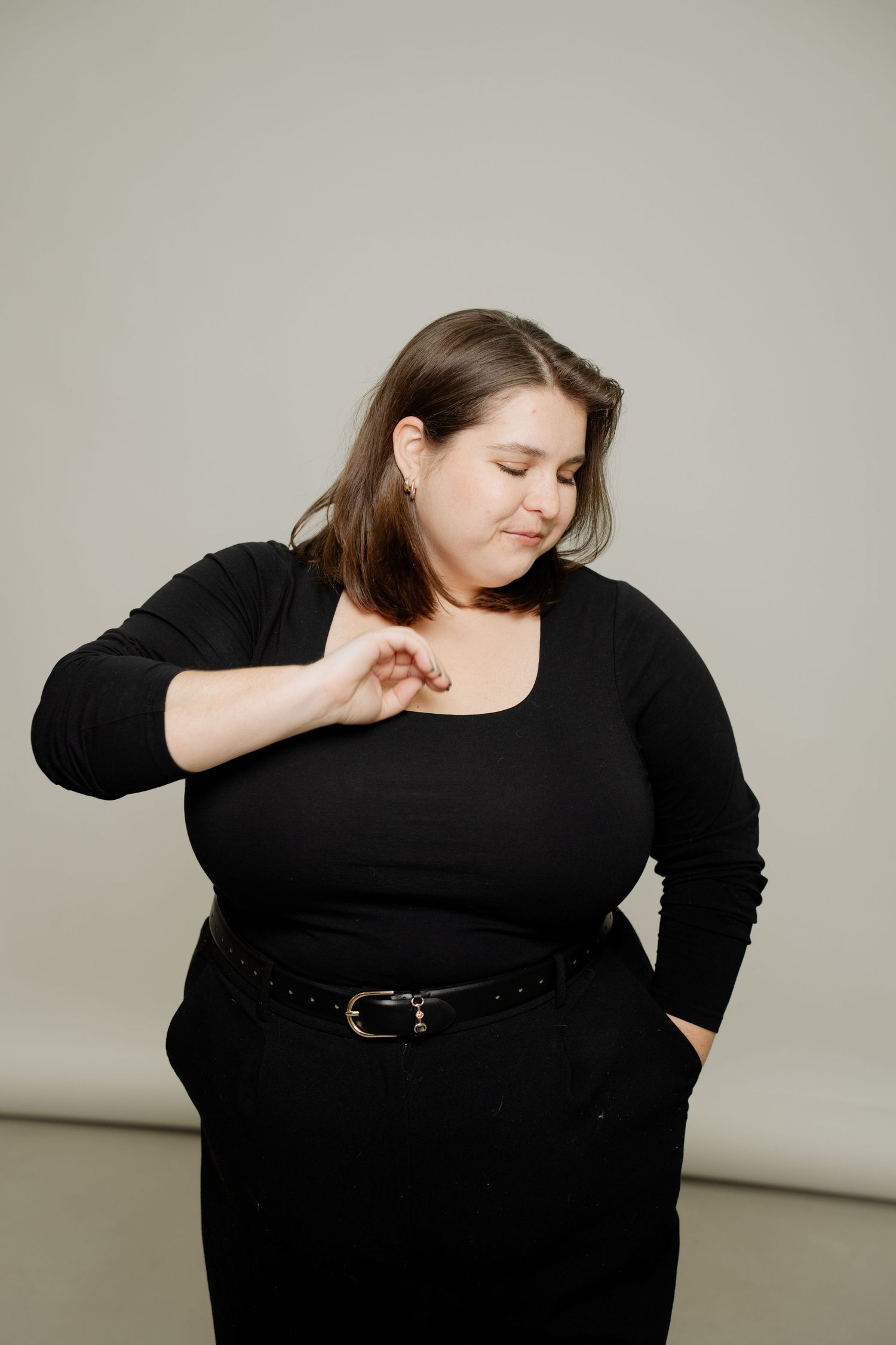 A series of images showing a person in black clothing bending and twisting against a light gray studio backdrop.