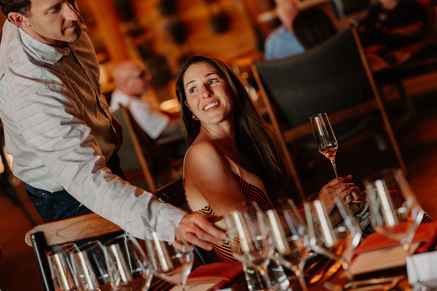 At a wine tasting event, guests sit at a table with multiple wine glasses arranged for sampling and tasting.