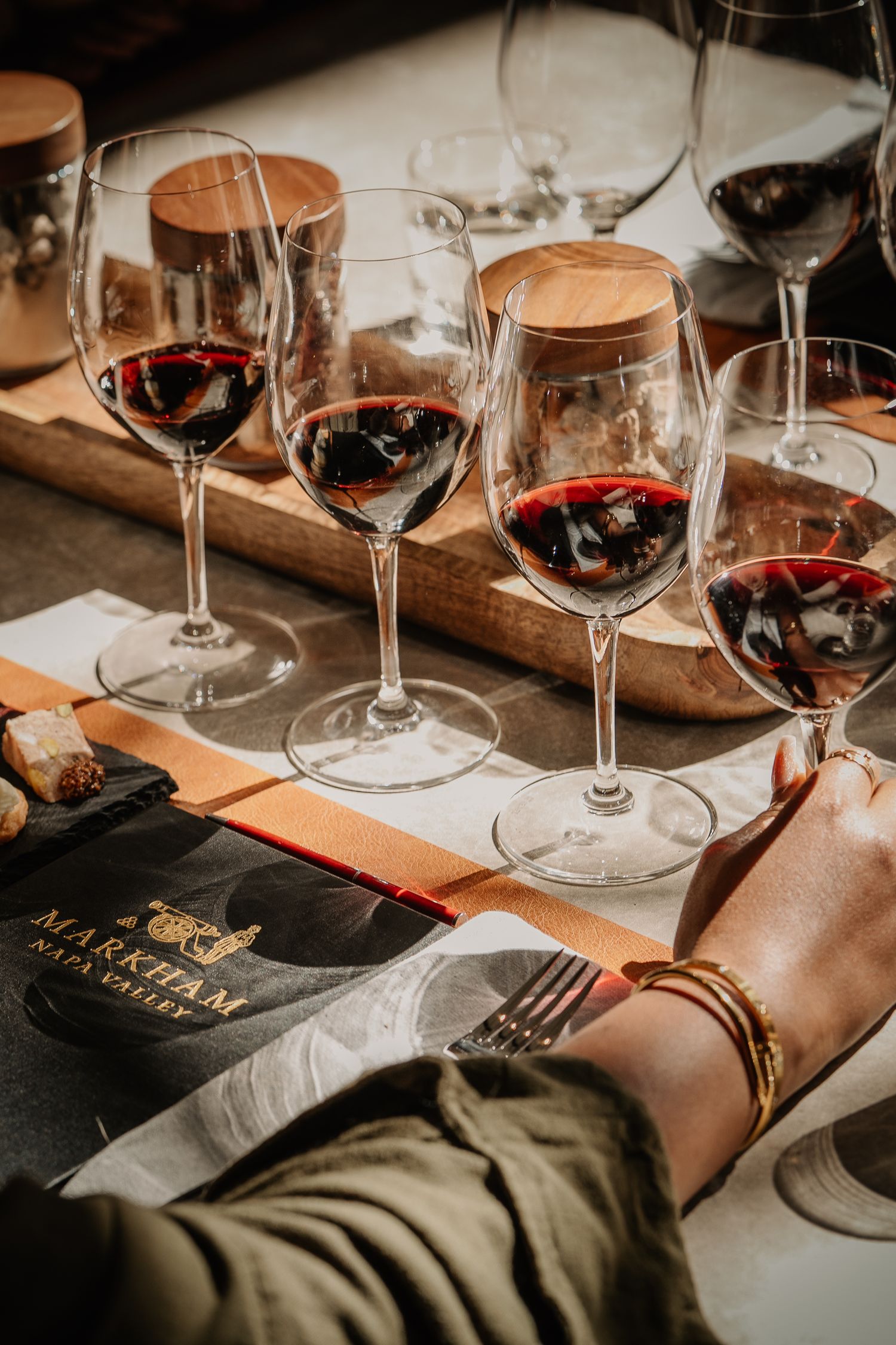 Multiple glasses of red wine on a tasting table at Markham Napa Valley winery.