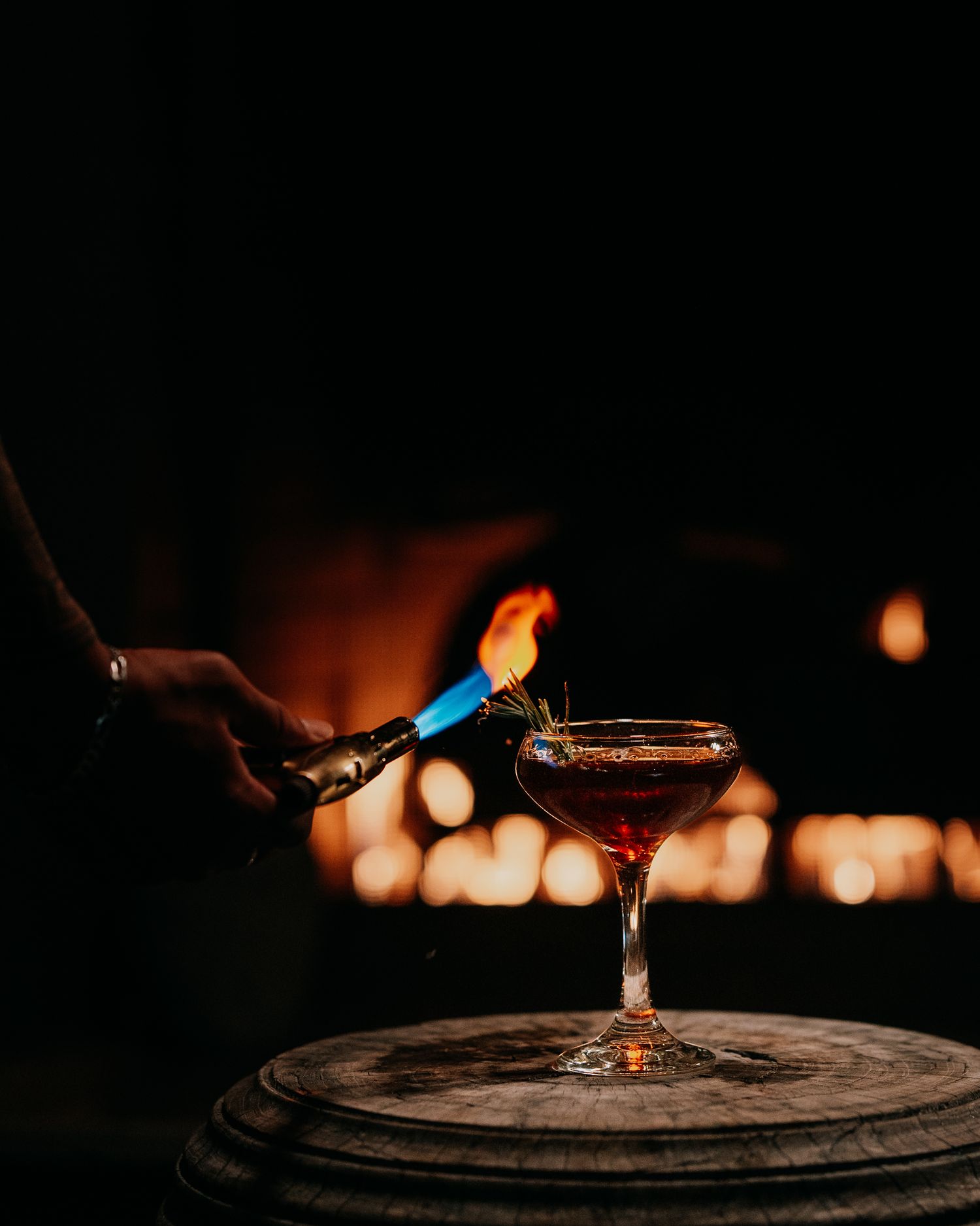 Pouring red wine into a glass against a dark background with bokeh lights creates an elegant ambiance.