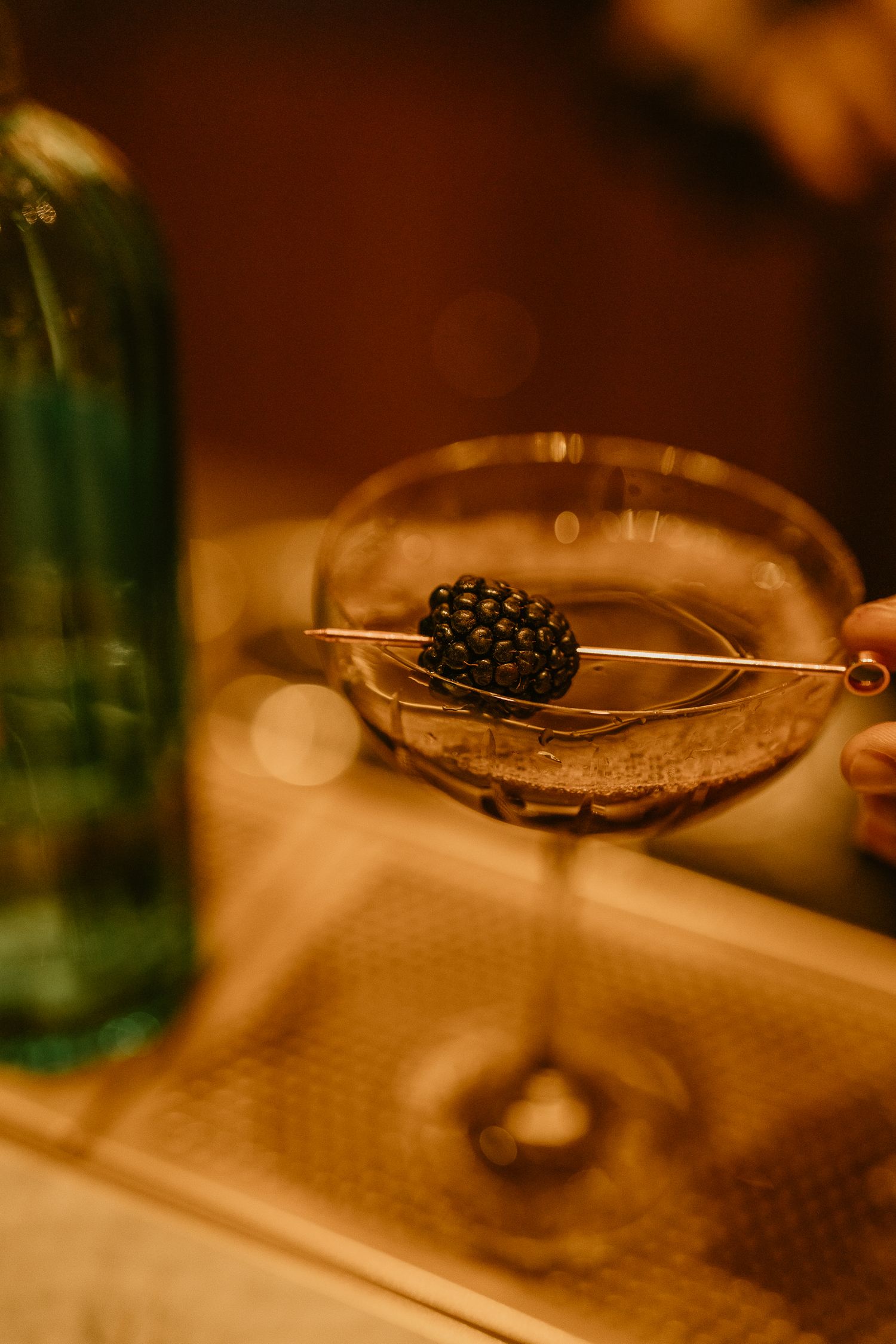 A sequence of close-up shots showing a spoon being dipped into a glass of dark liquid.