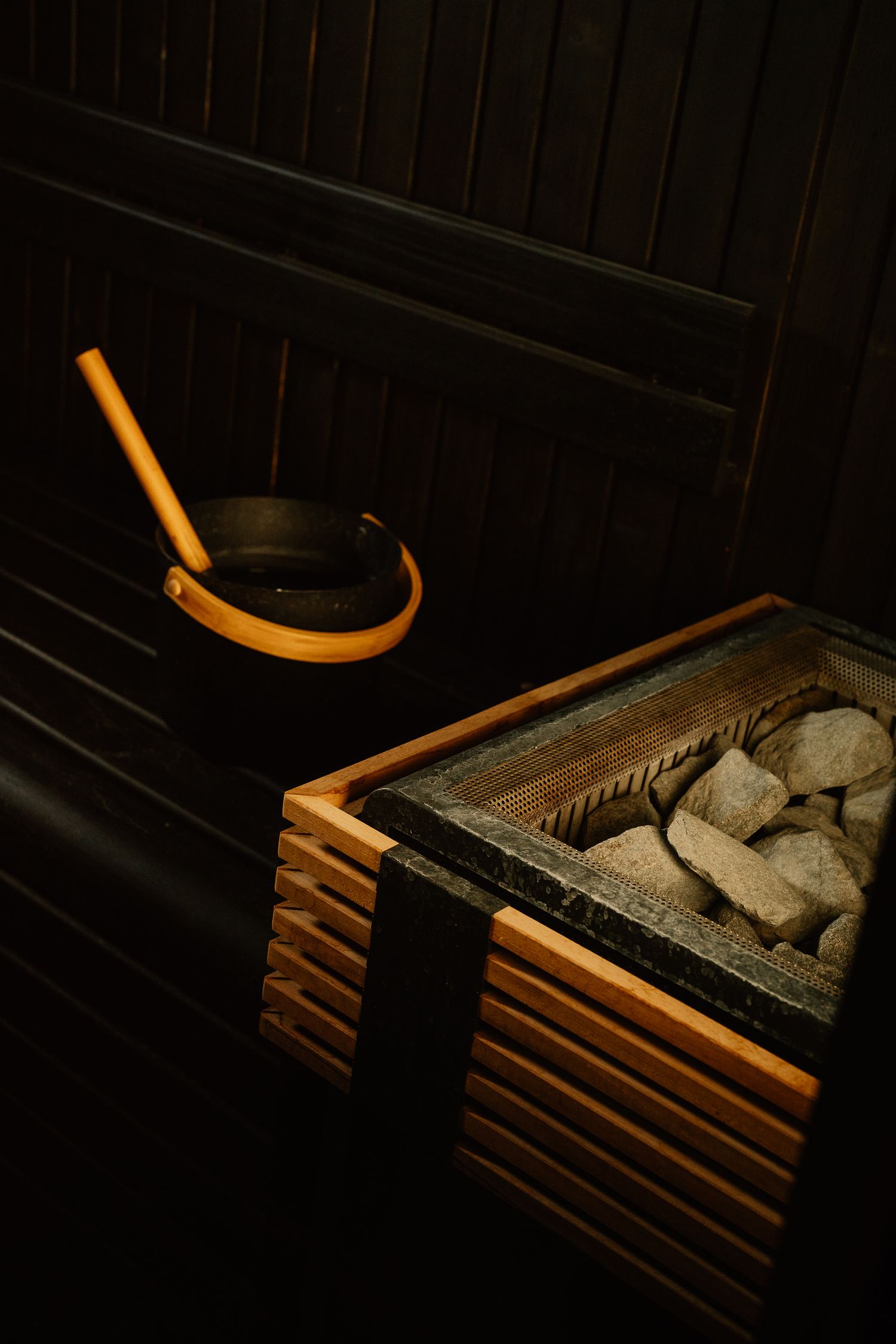 Wooden logs stacked in a dark rustic setting create a cozy architectural pattern.