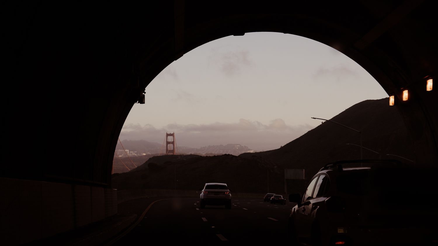 Silhouettes of five dark scenes with the Golden Gate Bridge visible against a dusky sky at sunset.
