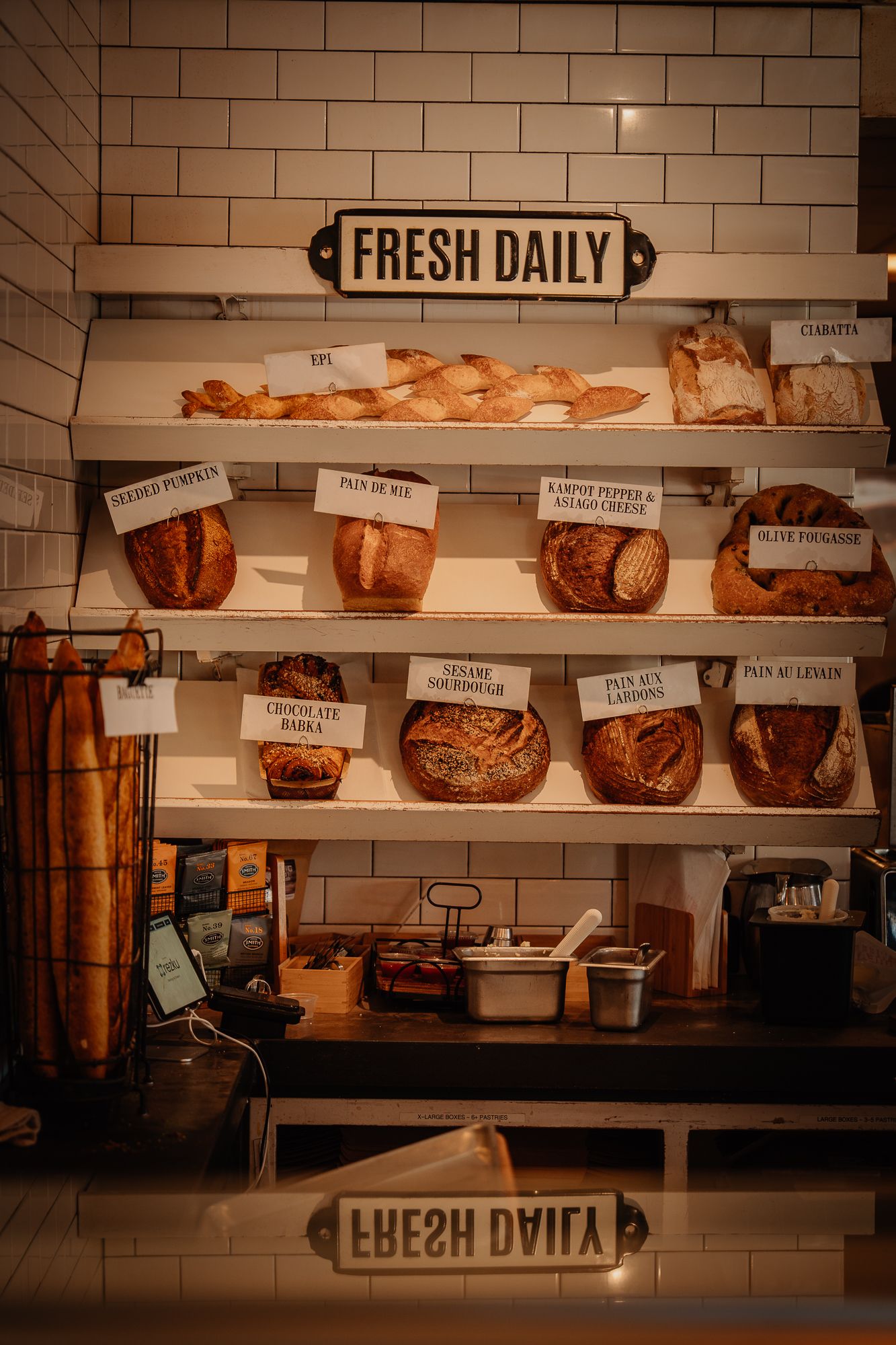 Artisan bakery display shelf with fresh daily breads including sourdough, babka, and baguettes.